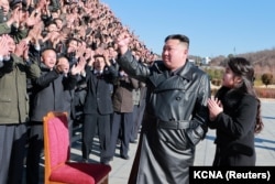 Lide Kore di No Kim Jong Un ak pitit fi li fe foto ak savan, enjenye ak responsab milite ki te travay sou ese nouvo misil Hwasong-17 enekontinantal la (ICBM) nan foto sa a ke ajans nouvel Kore di No a pataje ak lapres.