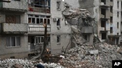 A man cleans debris of the destroyed house after recent Russian airstrike in Chasiv Yar, Ukraine, Nov. 27, 2022. 