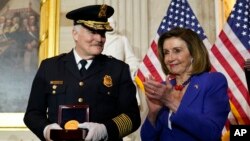 Lide Lachanm Depite Etazini, Nancy Pelosi, bat bravo pou Chef Lapolis Capitol la J. Thomas Manger pandan yon seremoni pou onore polisye ki te defann Capitol la, 6 Janvye 2021. 