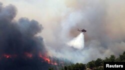 24 Temmuz 2023 - Rodos'ta halen devam eden yangınlara uçak ve helikopterler havadan müdahale ediyor. 