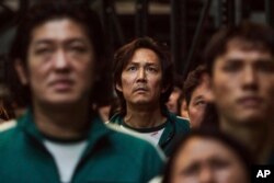 Lee Jung-jae (mitan) nan yon sen seri televize popile Koreyen "Squid Game" nan foto sa a ke Netflix pibliye. (Netflix via AP)