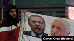 Başbakan Erdoğan ve Fethullah Gülen'in resimlerinin bulunduğu bir afişi tutan gösterici Erdoğan'a istifa çağrısında bulunuyor