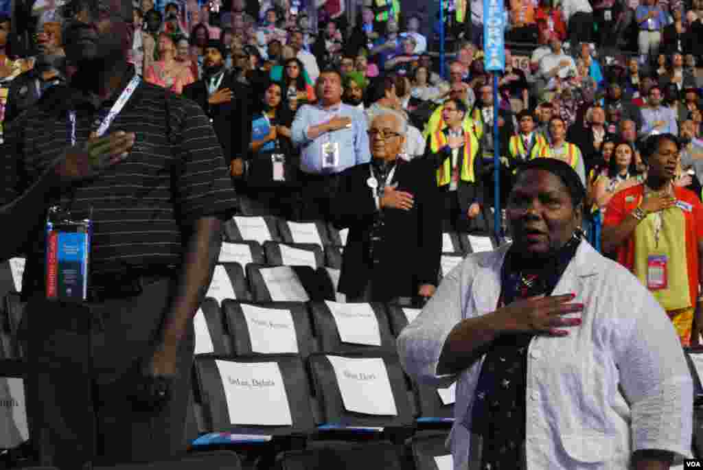 South African mourners hold posters of former president Nelson Mandela, while chanting slogans as the convoy transporting his remains passes by in Pretoria, Dec. 11, 2013.