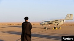 FILE PHOTO: An Iranian cleric stands near a drone during a military exercise in an undisclosed location in Iran