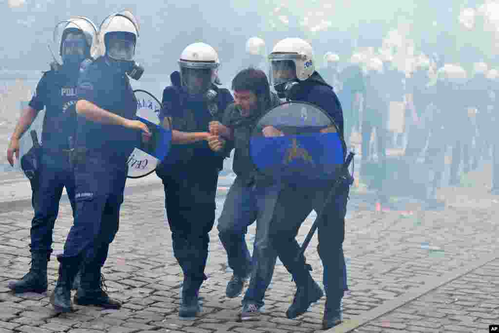 Riot police detain a protester as he and others demonstrate to blame the ruling AK Party (AKP) government on the mining disaster in western Turkey, in Ankara May 14, 2014. Rescuers pulled more dead and injured from a coal mine in western Turkey on Wednesd