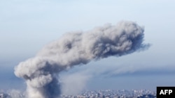 TOPSHOT - This picture taken from the Israeli side of the border with the Gaza Strip shows smoke plumes rising from explosions above destroyed buildings in the northern Gaza Strip on January 14, 2025, amid the ongoing war between Israel and Hamas. (Photo 